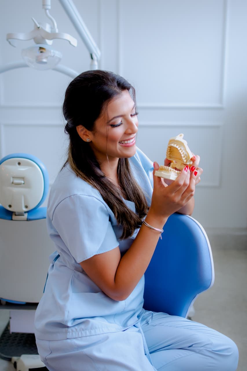 Dra. Gabriela Carli analisando um modelo dental na clínica